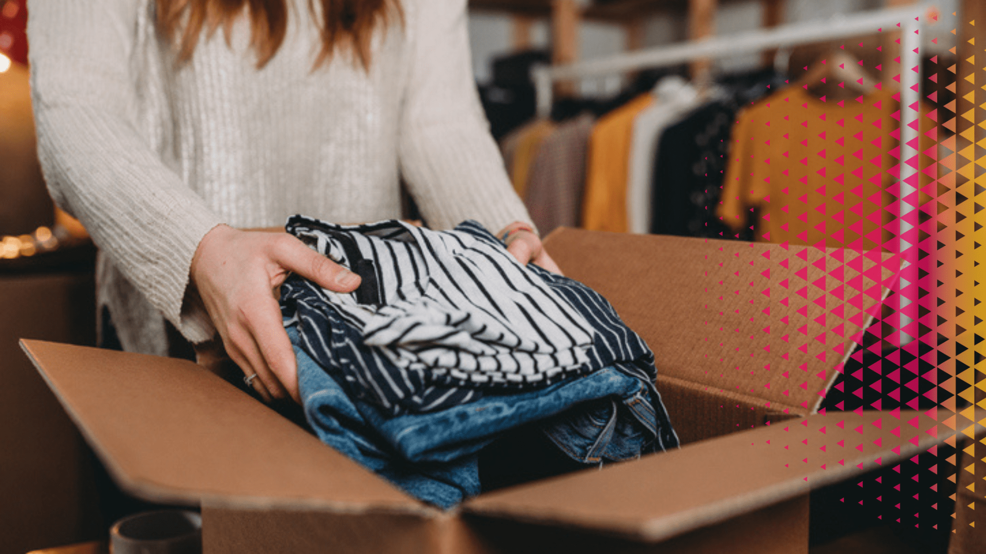 Une personne range soigneusement des vêtements de seconde main (jeans et haut rayé) dans un carton d'expédition pour le retail mode.