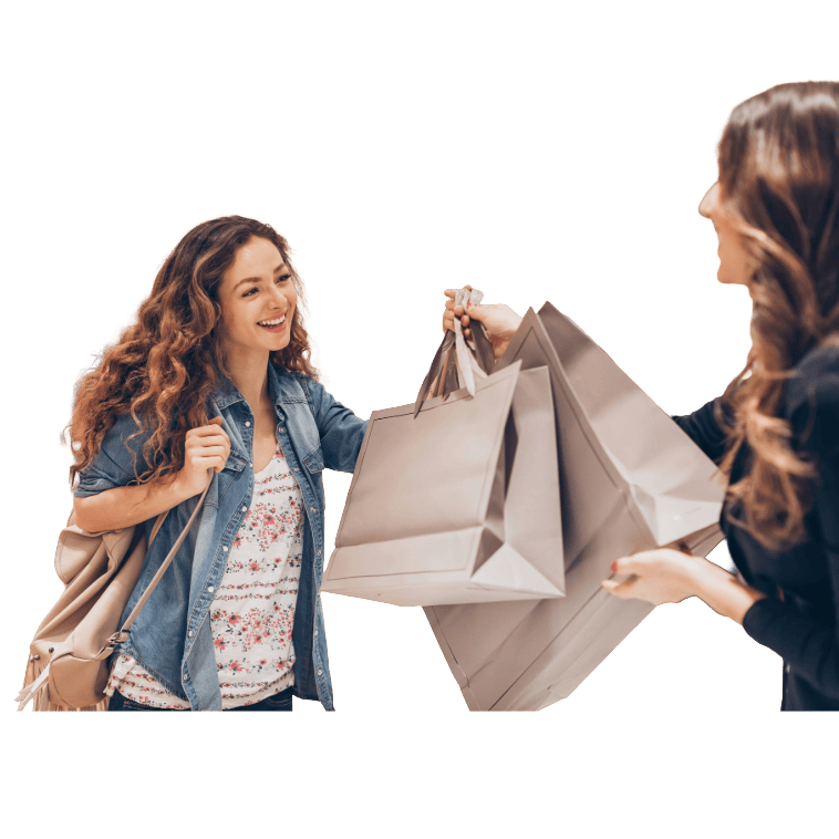 Vendeuse remettant des sacs de shopping à une cliente souriante en boutique de mode.